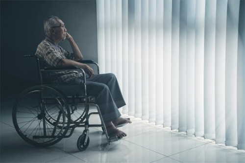 depressione nell'anziano - anziano su una carrozzina di fronte a una vetrata con tenda chiusa